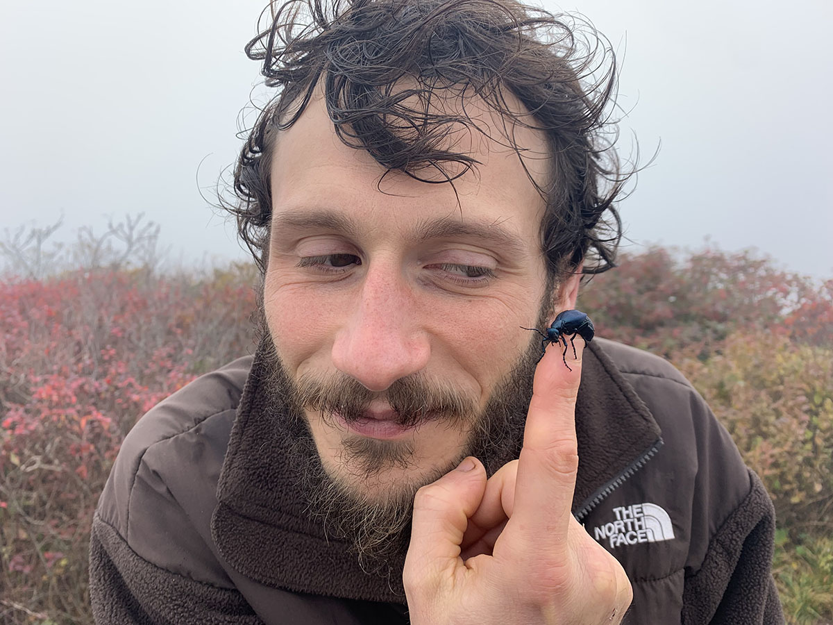 Frank-Salzano-enjoying-the-company-of-a-black-beetle Frank Salzano enjoying the company of black beetle crawling around his finger